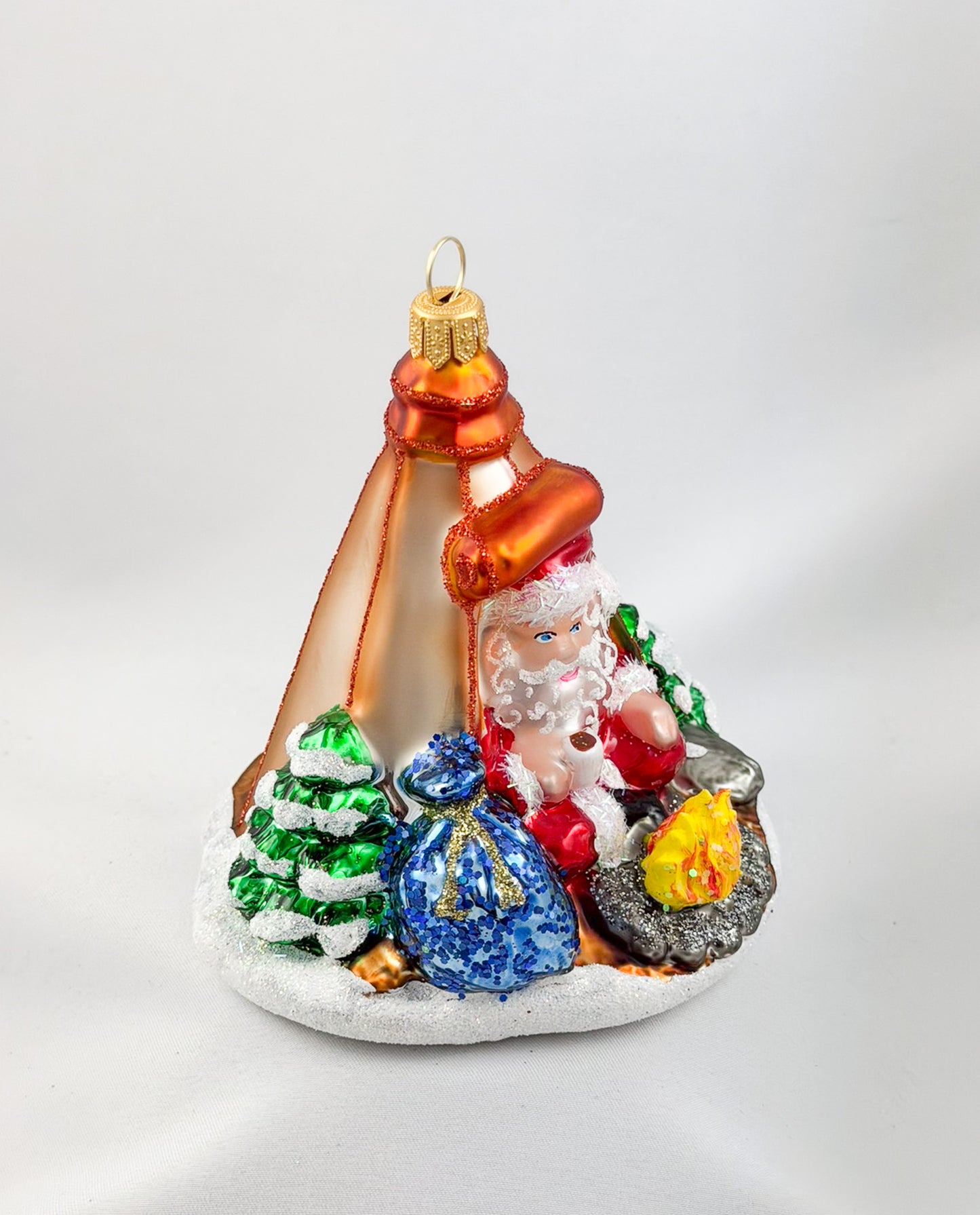 Santa is sitting comfortably in his tent by the campfire.