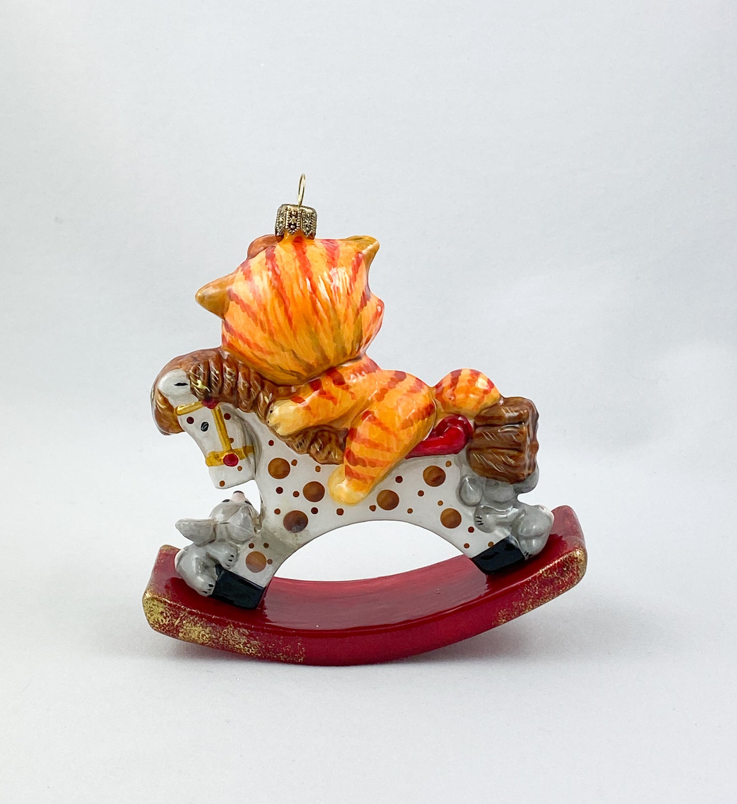The red tiger cat rides on the spotted rocking horse AtlasArt