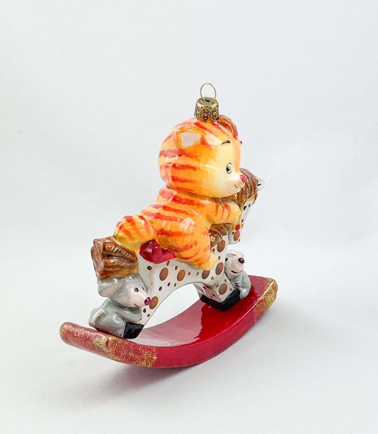 The red tiger cat rides on the spotted rocking horse AtlasArt