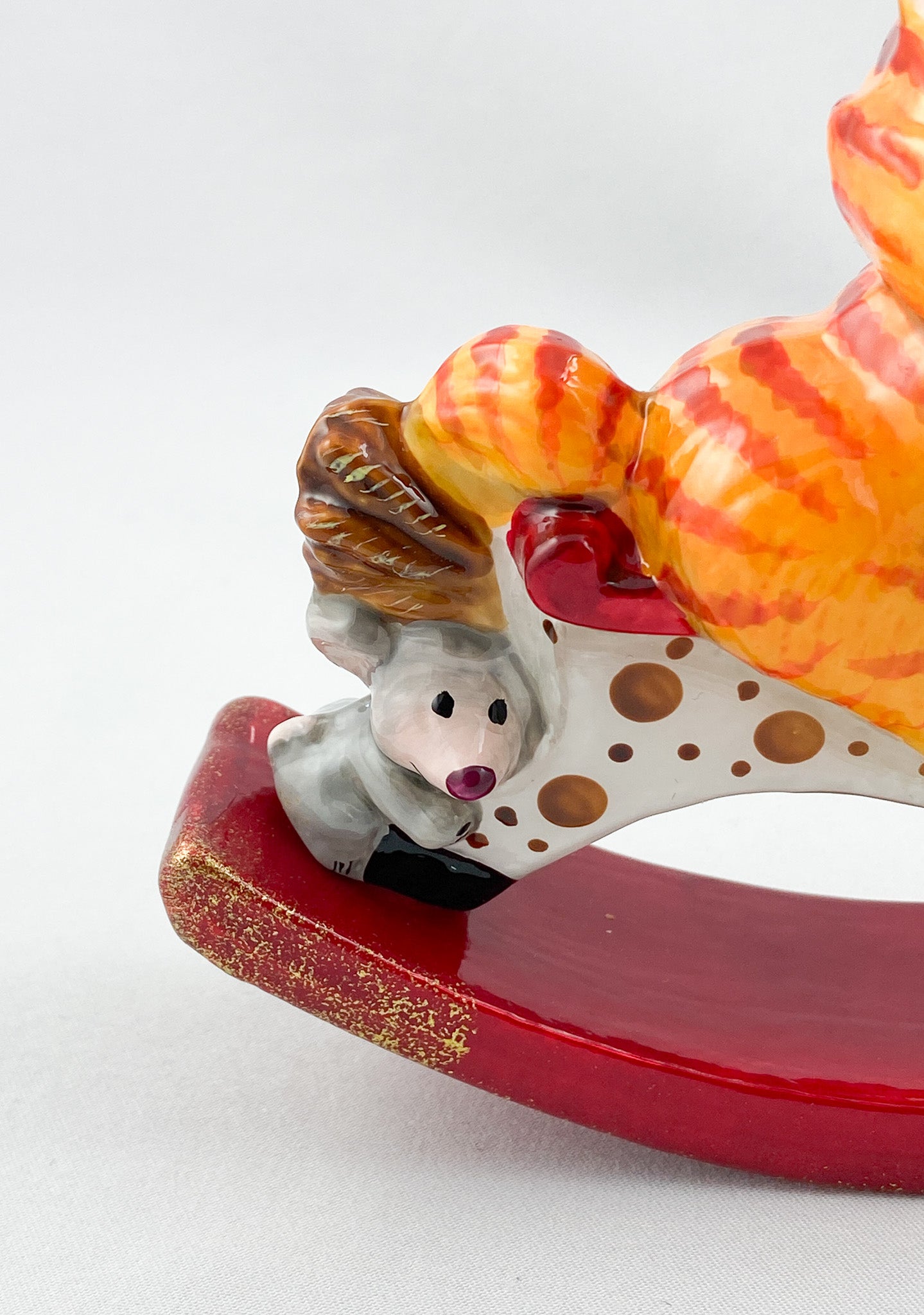 The red tiger cat rides on the spotted rocking horse AtlasArt