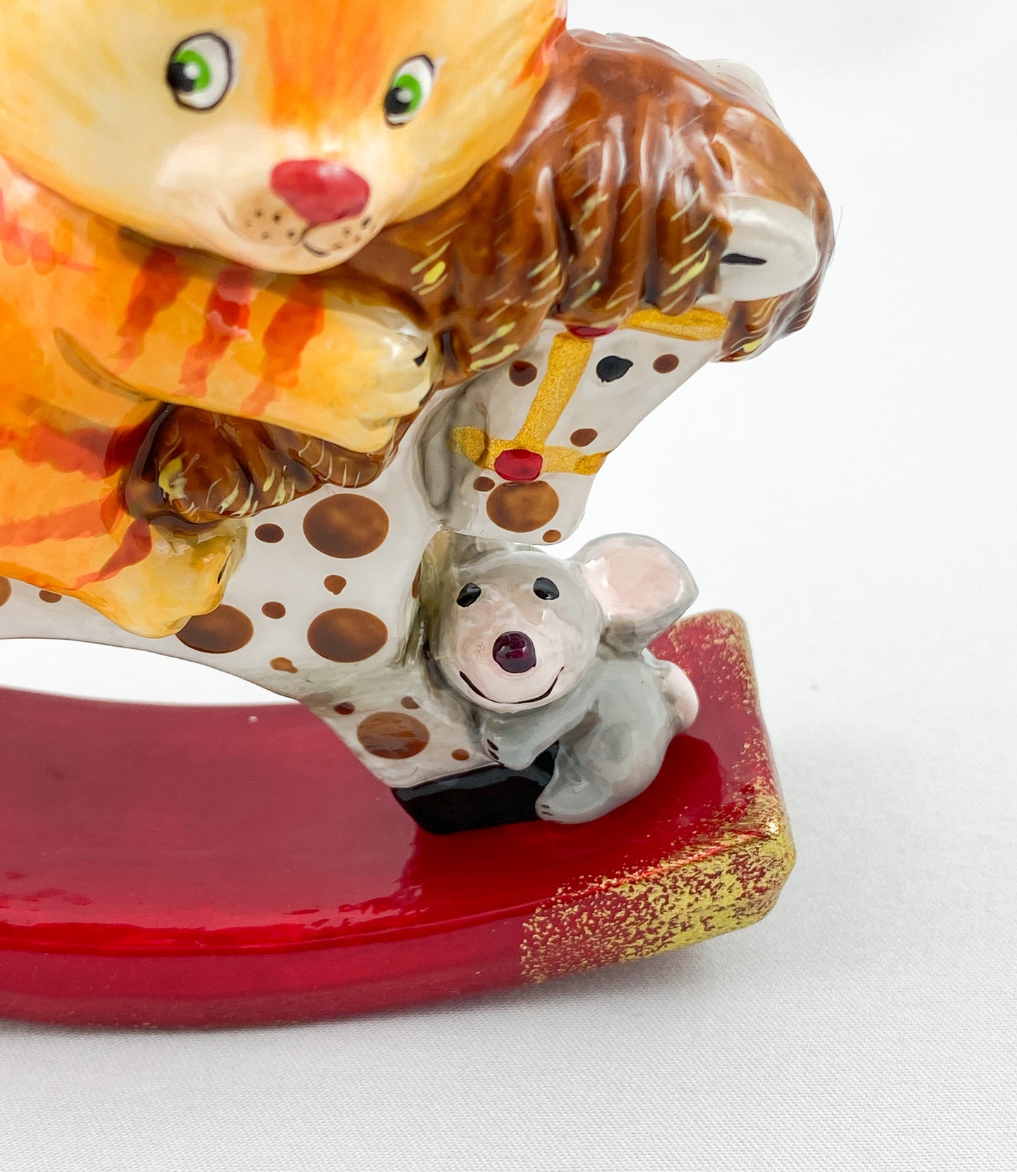 The red tiger cat rides on the spotted rocking horse AtlasArt