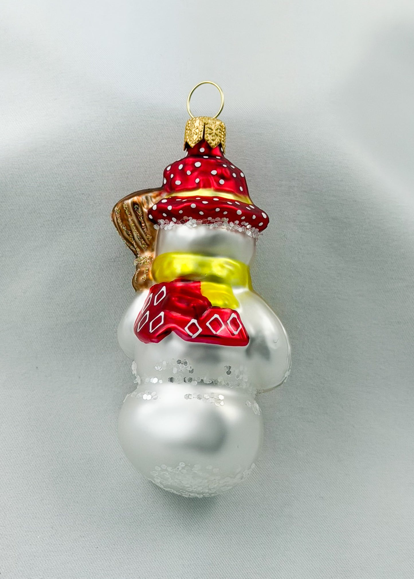 Schneemann mit Besen und rotem Hut