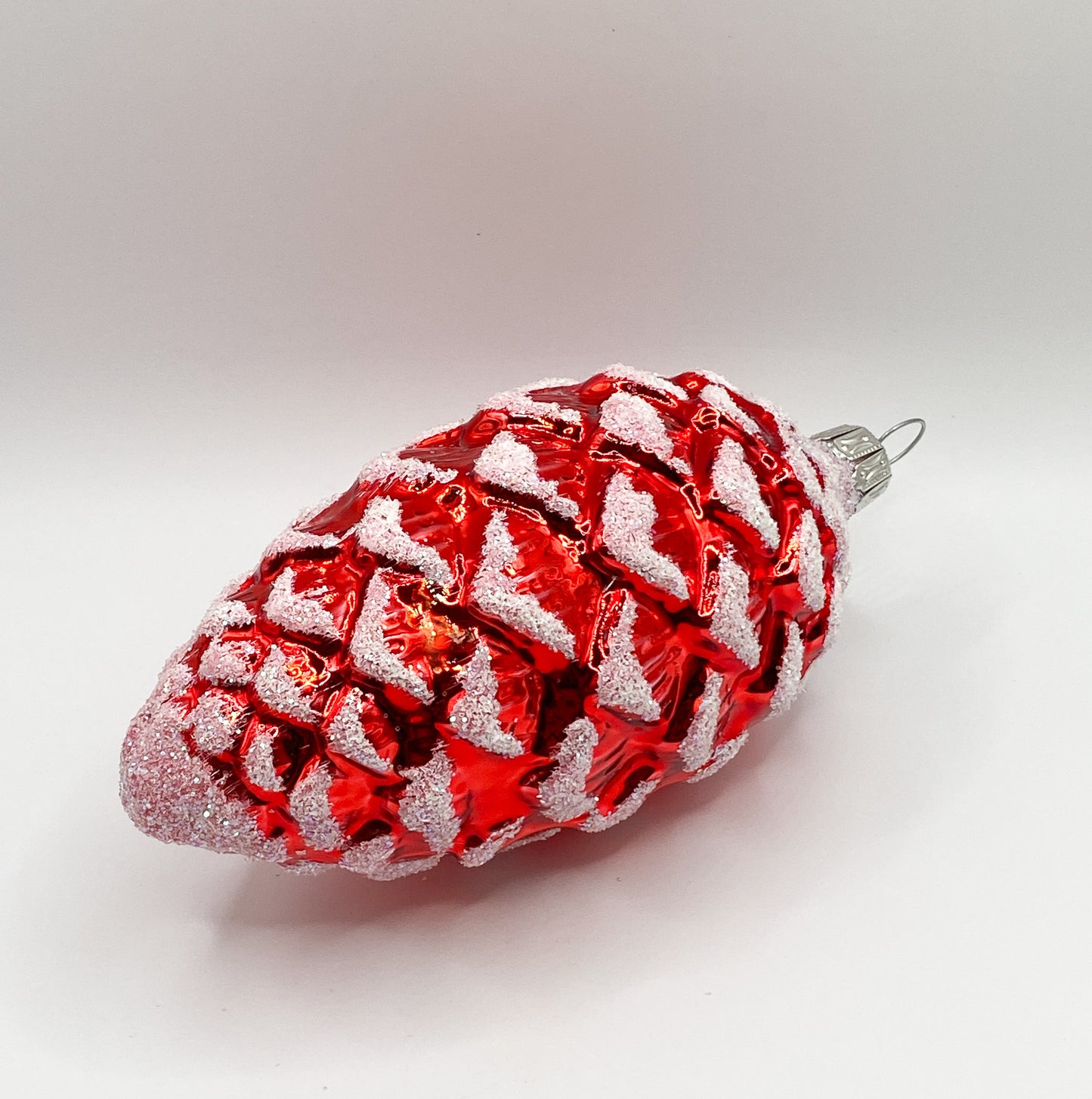 Red shiny fir cone with white glitter