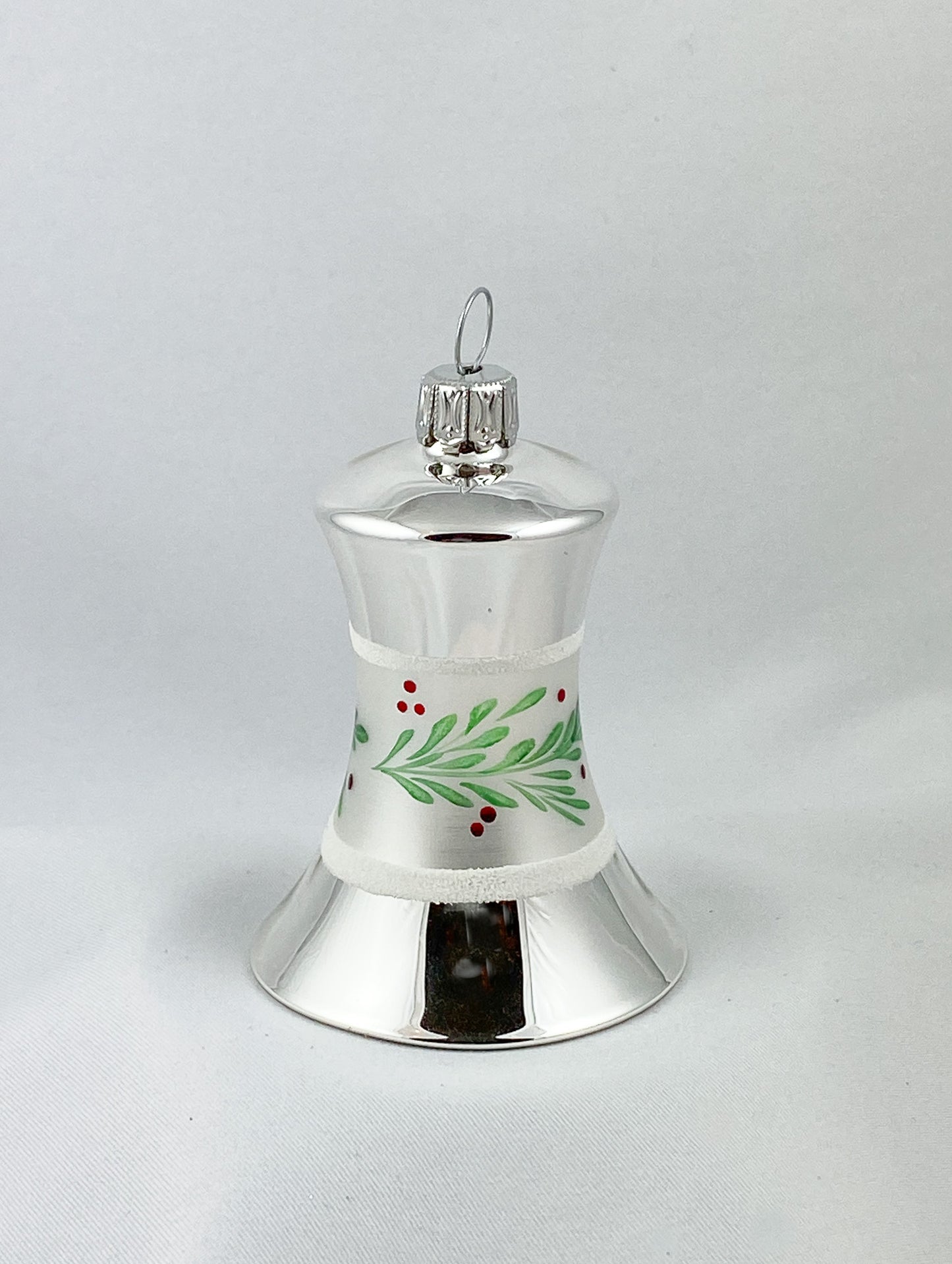 Silberne Weihnachtsglocke mit grünem Zweig