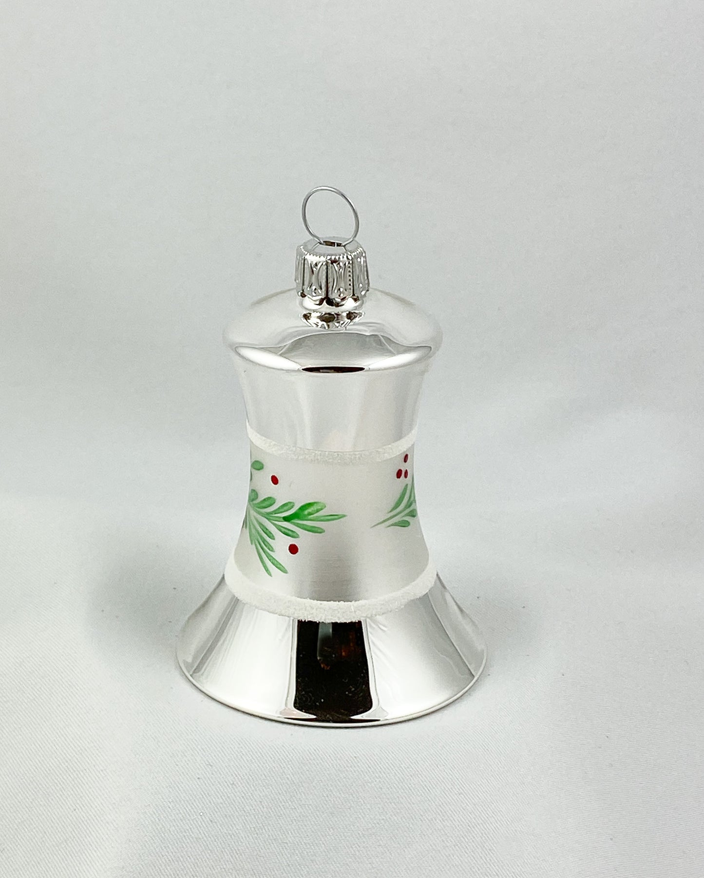 Silberne Weihnachtsglocke mit grünem Zweig