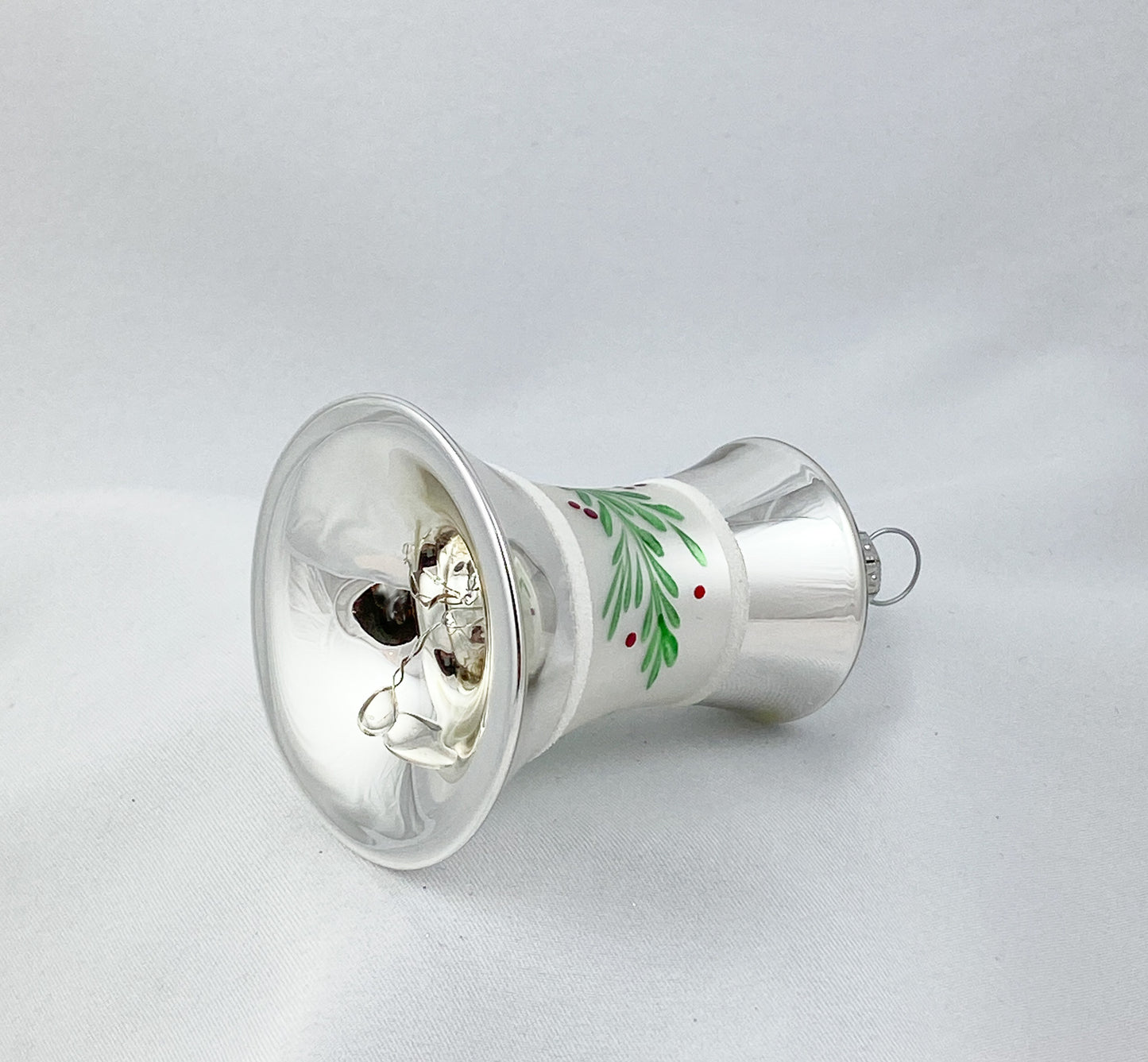 Silberne Weihnachtsglocke mit grünem Zweig