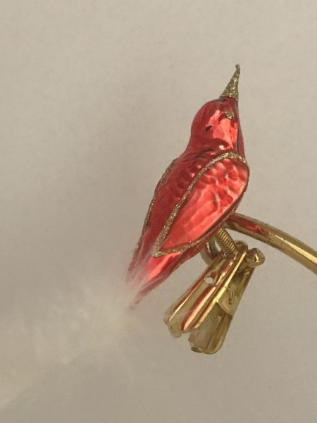 Kleines rotes Vögelchen mit goldumrahmten Flügeln