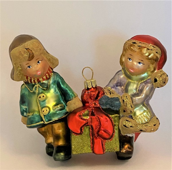Mädchen und Junge tragen ein grosses Weihnachtsgeschenk, KOMOZJA MOSTOWSKI
