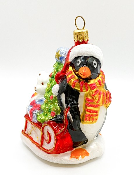 Pinguin bringt den Weihnachtsbaum und Geschenke auf dem Schlitten