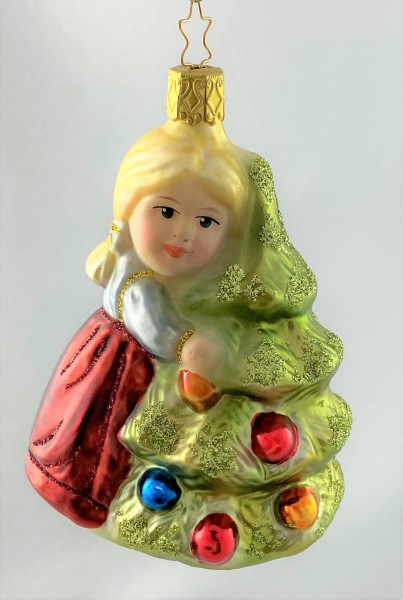 Das kleinen Mädchen umarmt den Christbaum