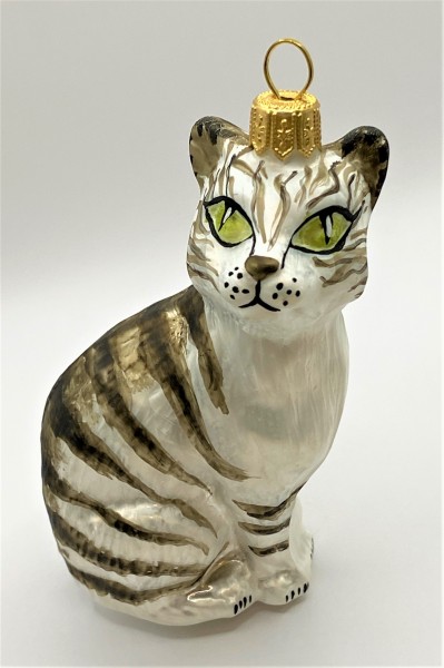 Aufrecht sitzende weisse Tigerkatze mit grünen Augen