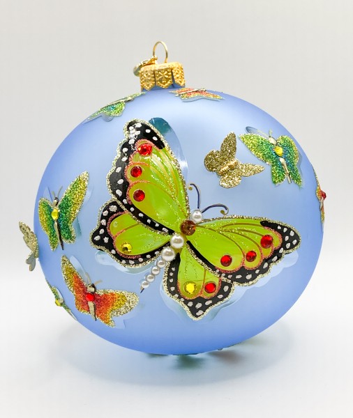 Transparente hellblaue Kugel mit strukturiert gemalten Schmetterlingen und metallenen Schmetterling